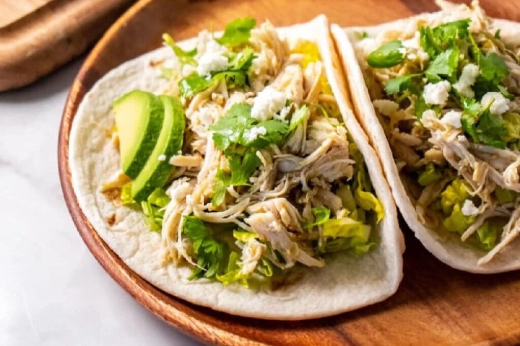A close up shot of salsa verde chicken tacos.