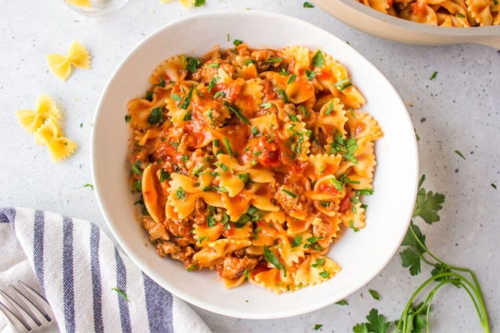 A close up shot of sausage bow tie pasta.