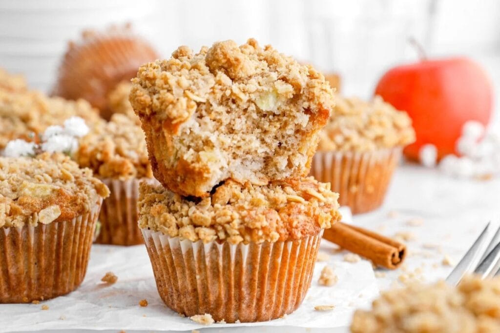 Apple oatmeal crumble muffins on parchment paper.