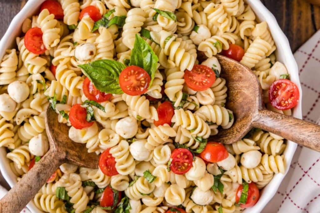 Caprese pasta salad in a white bowl.