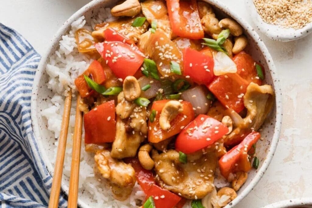Chicken and bell pepper stir fry on a white plate.