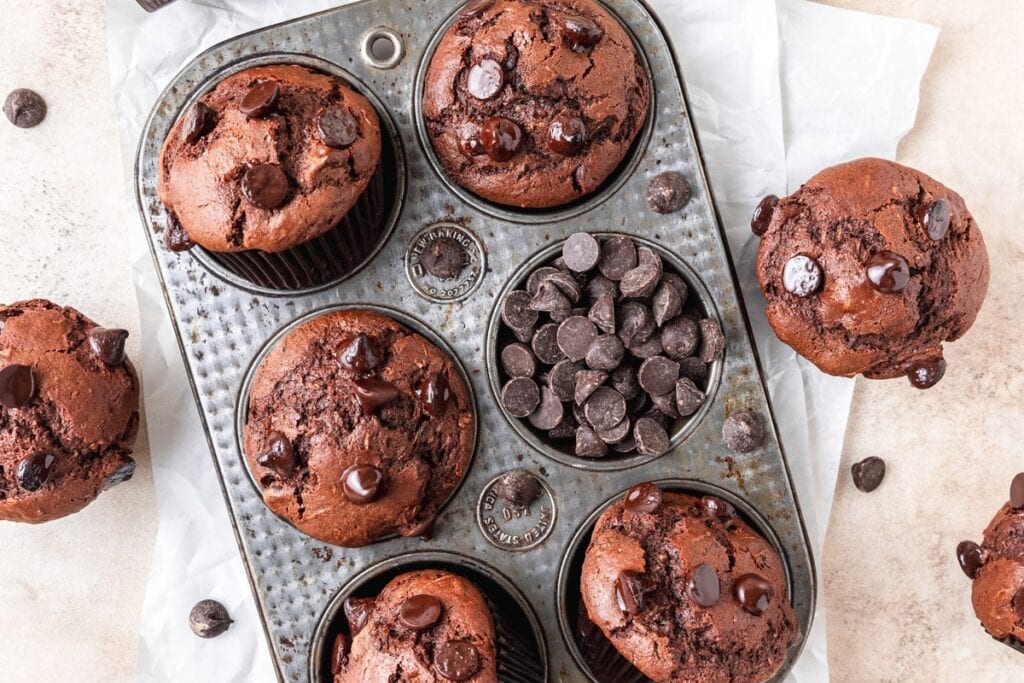 Chocolate zucchini muffins on a baking tray.