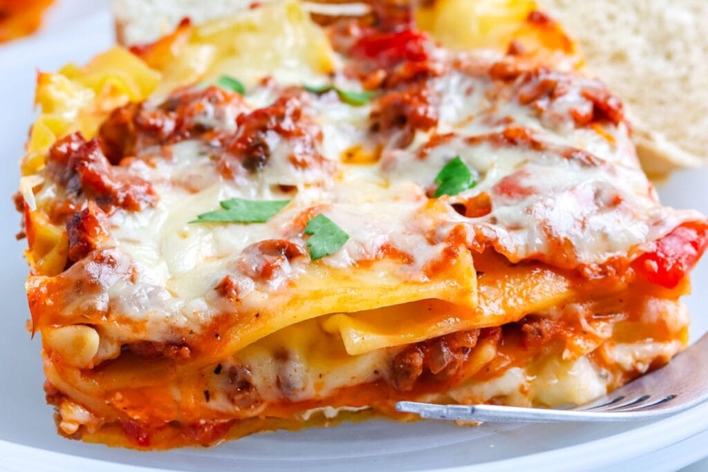 Close-up of cream cheese lasagna on a white plate.