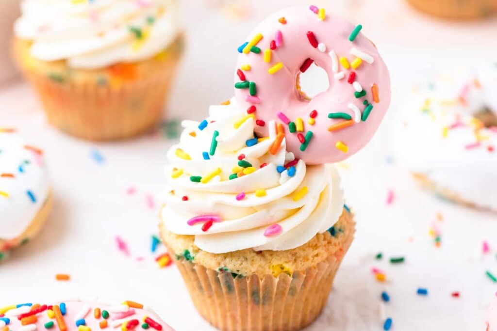 Funfetti donut cupcakes on a white table.