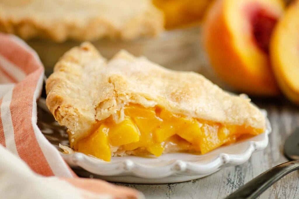 Homemade peach pie on a plate.