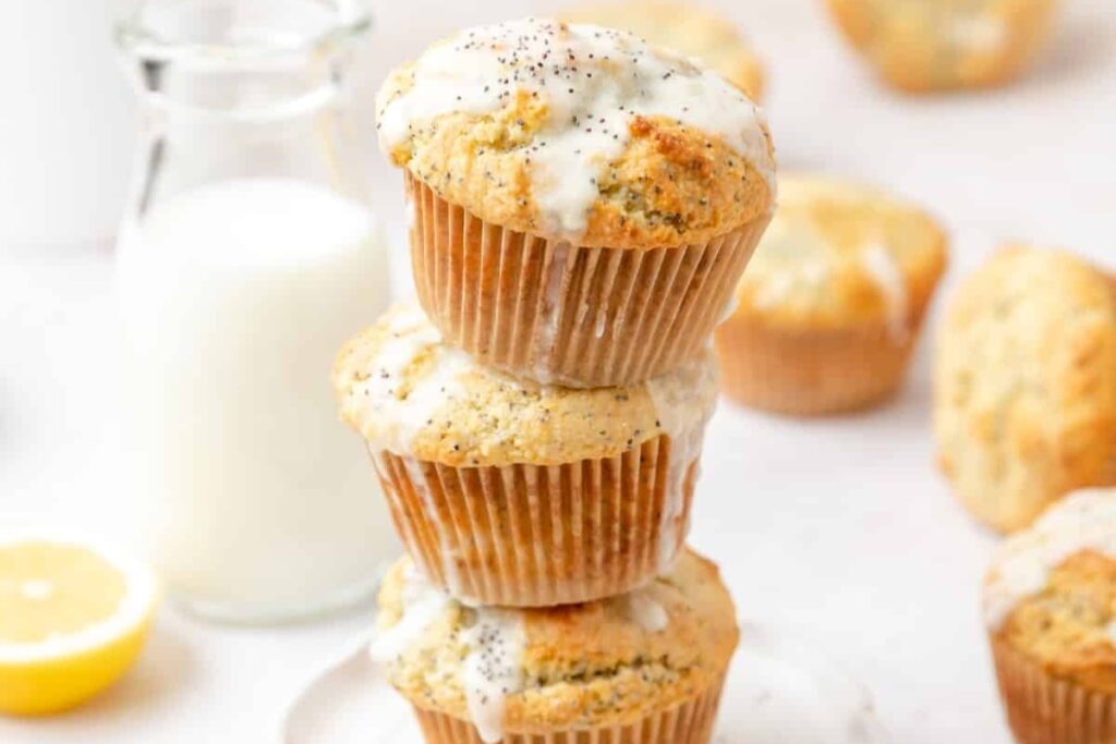 Stacked lemon poppy seed muffins on a plate.