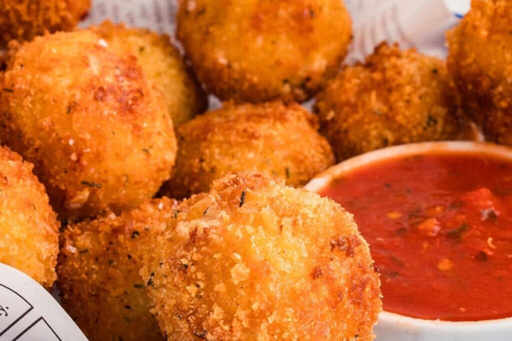 Close-up of mac and cheese bites with dipping sauce.