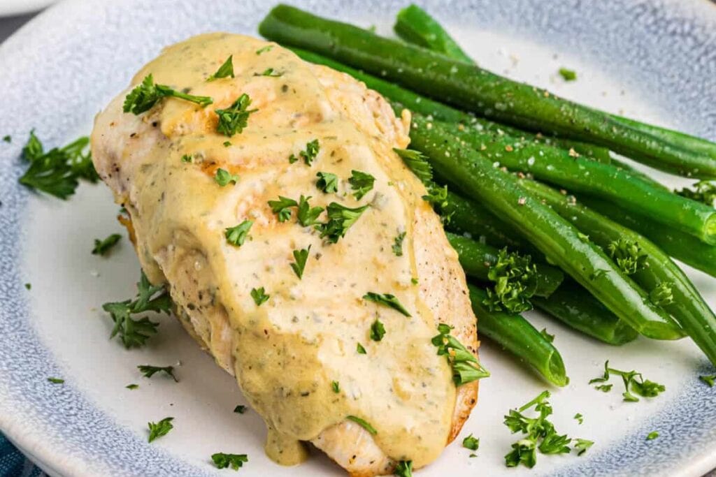 Mustard chicken with green beans on a plate.