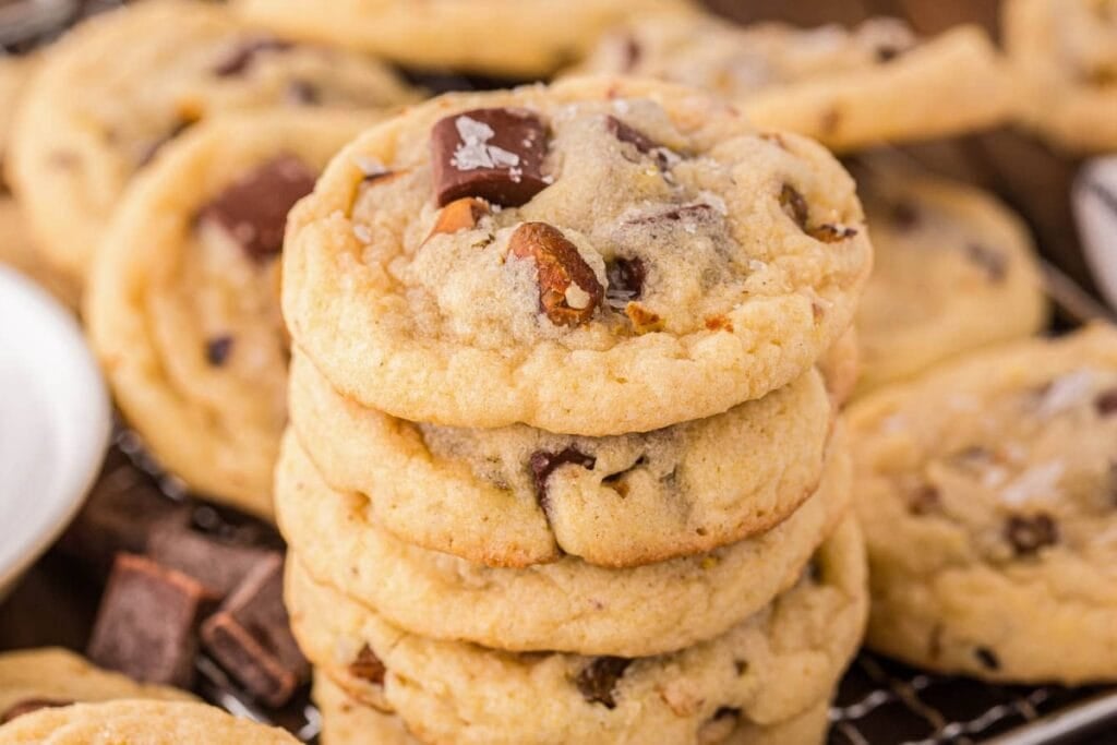 Pistachio cookies stacked on a cooling rack.
