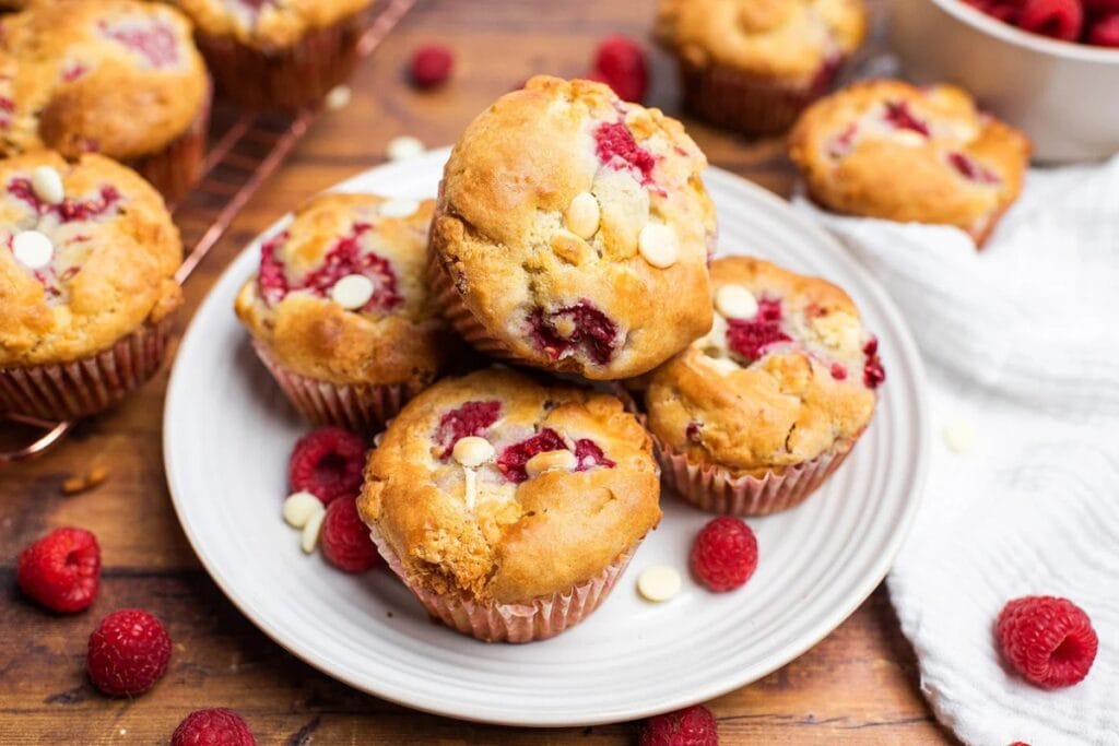 Raspberry white chocolate muffins on a plate.