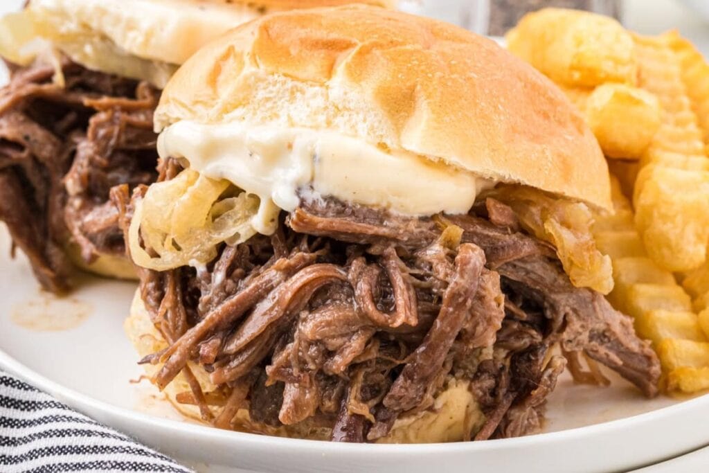 Shredded beef sliders on a plate.