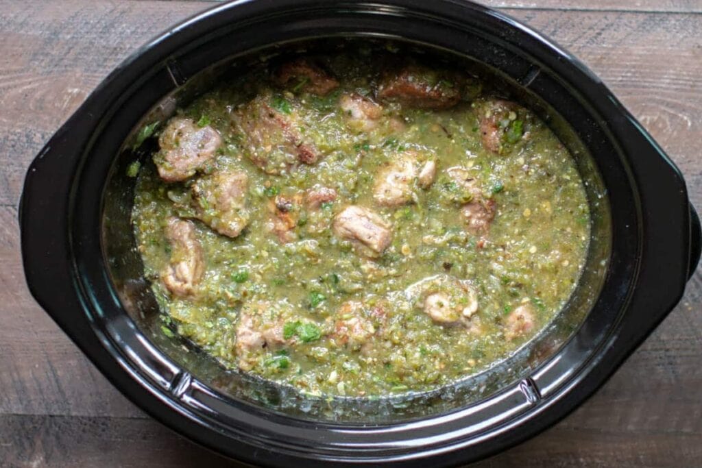 Slow cooker chile verde with chunks of pork in a green tomatillo sauce.