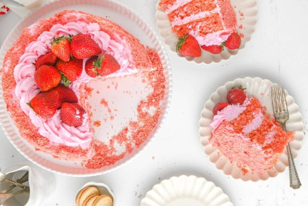 Strawberry crunch cake with strawberries on top and slices on plates.