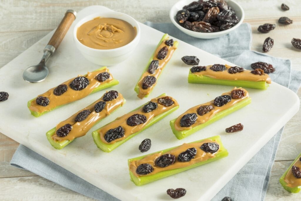 Celery sticks with peanut butter and raisins .