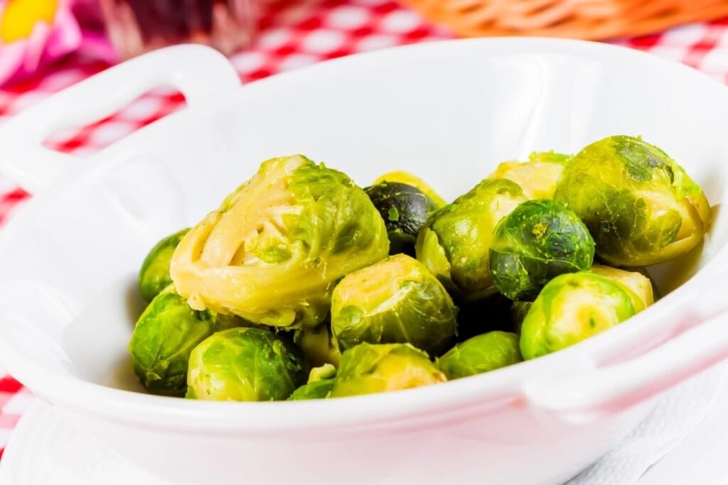 Brussels sprouts in a white serving bowl.