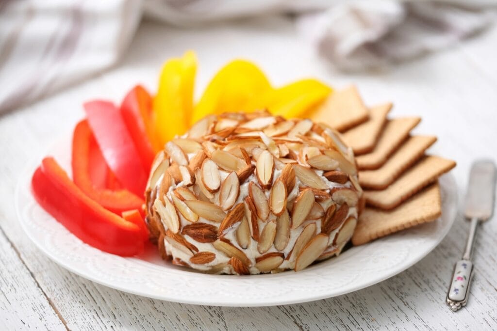 Almond-coated cheese ball on a plate.