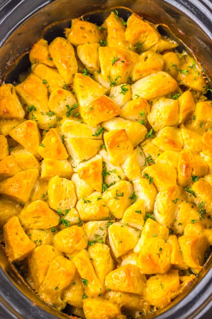 chicken pot pie casserole in slow cooker topped with golden biscuits