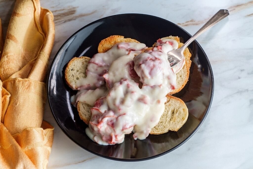 Chipped beef in creamy gravy served over toast on a plate.