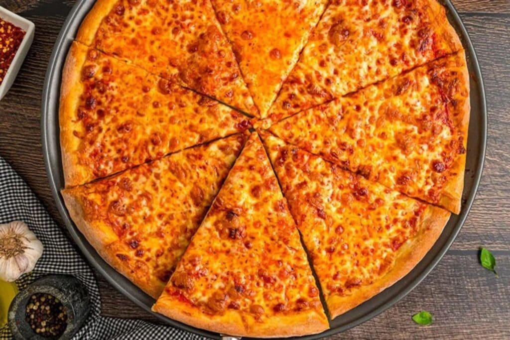 Sliced cheese pizza on a round pan.