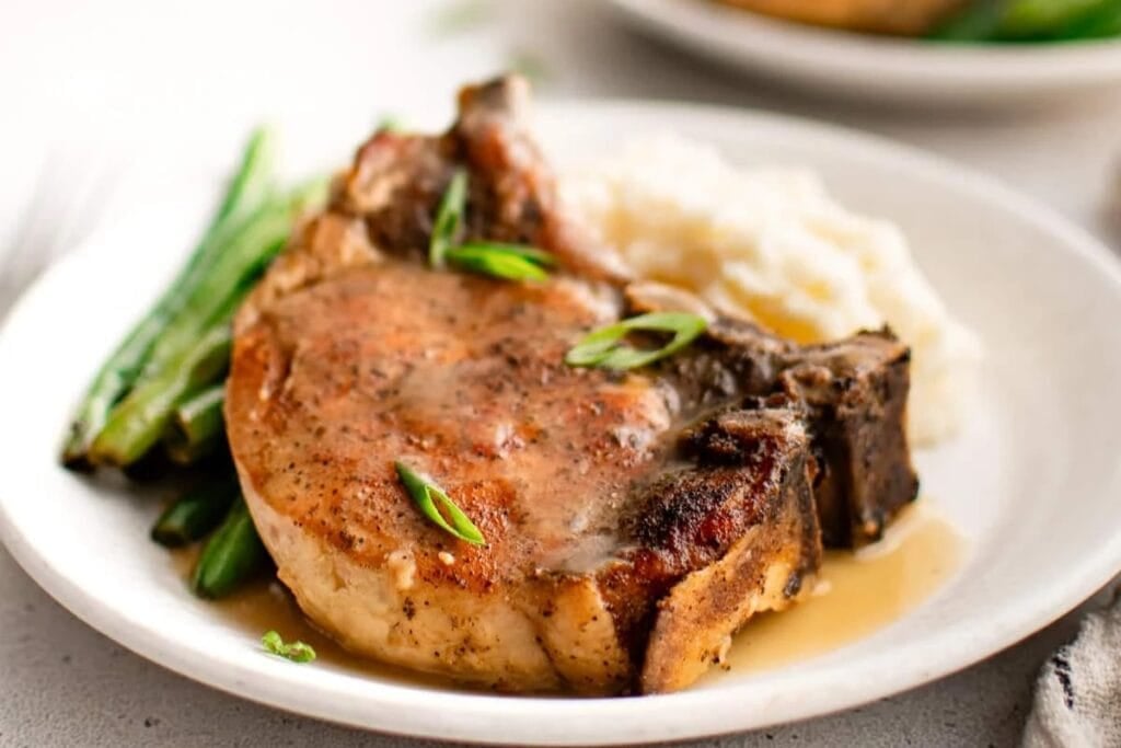 Crockpot pork chops on a plate.