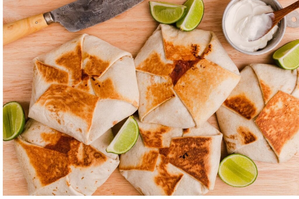 Crunchwrap supreme served on a wooden board.