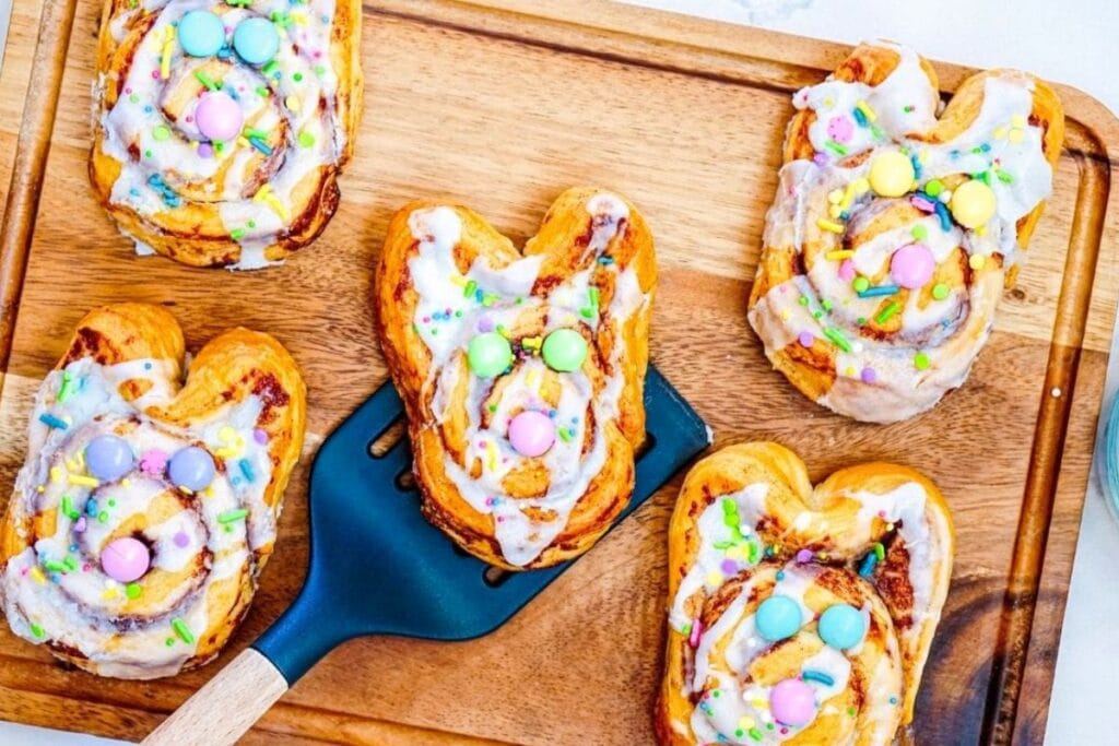 Easter bunny cinnamon rolls on cutting board.