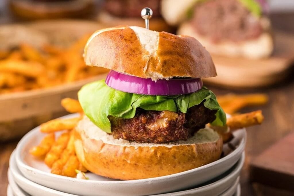 Gorgonzola buffalo burgers in a pretzel bun on a plate.