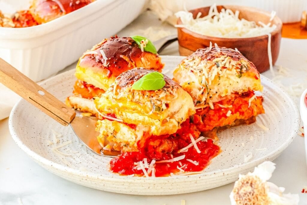 Hot honey chicken Parmesan sliders on a plate.