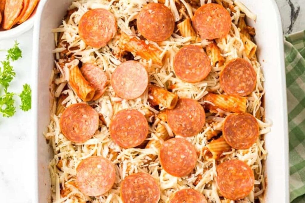 Pizza pasta bake with ground beef in a baking dish.