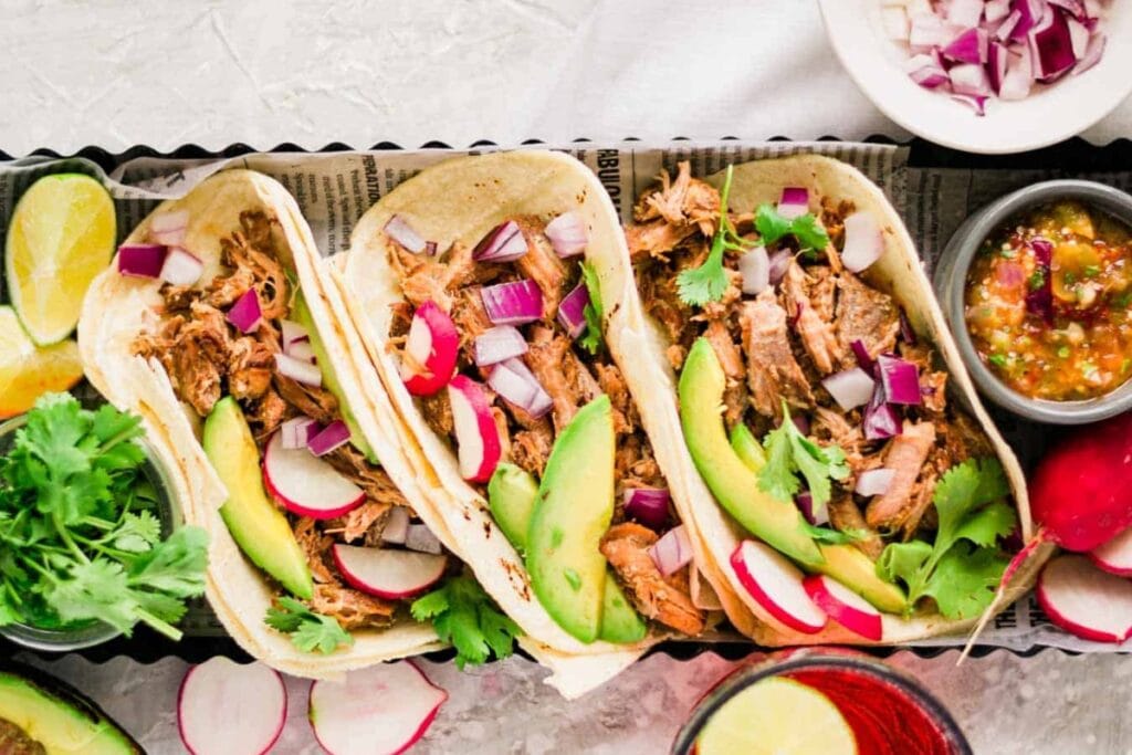 Pork carnitas street tacos on a plate.