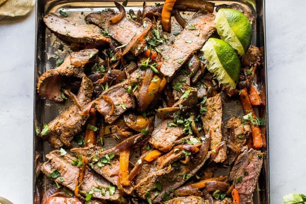 Steak fajitas on a sheet pan.
