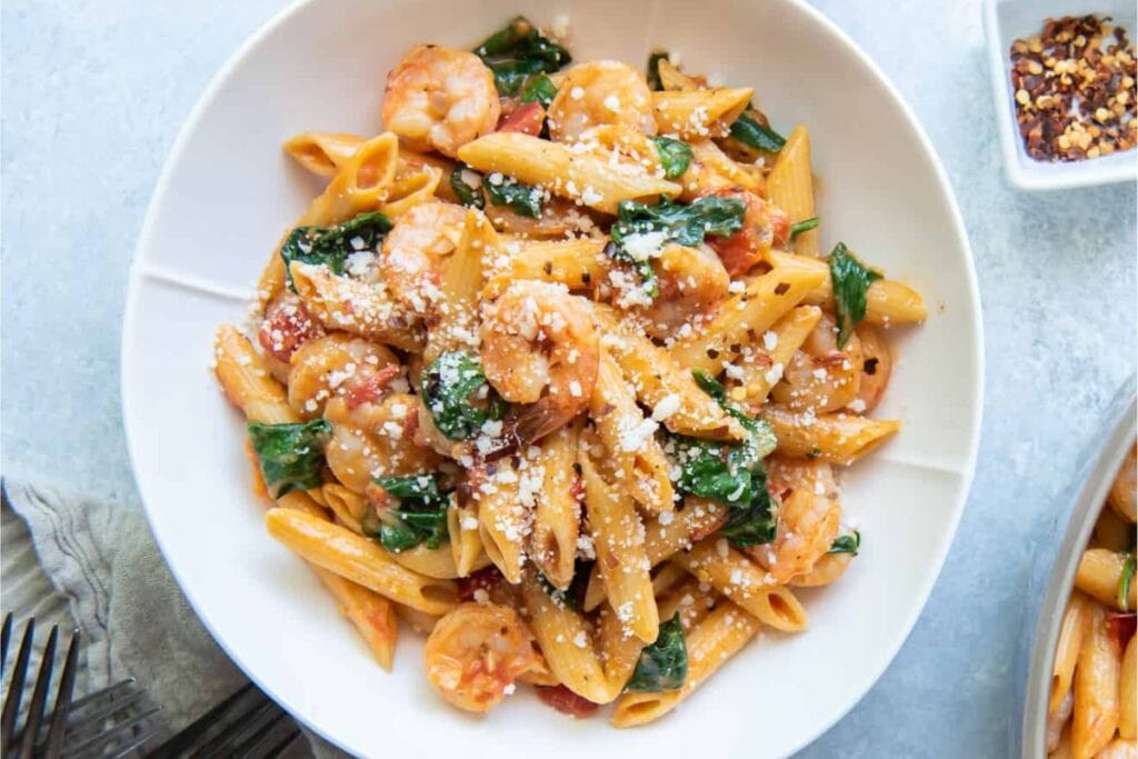 Shrimp and spinach pasta on a plate.