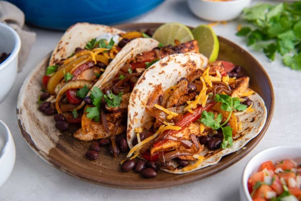Chicken fajitas with peppers and onions on a plate.