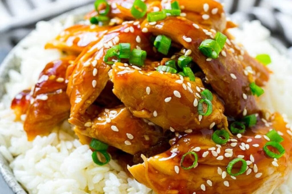 Slow cooker teriyaki chicken served over rice in a bowl.