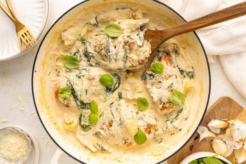 Spinach artichoke chicken in a skillet.
