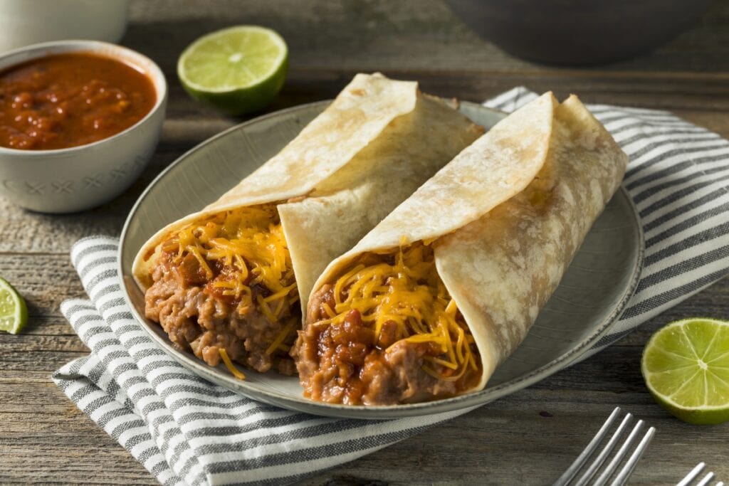 Bean and cheese burritos on a plate.