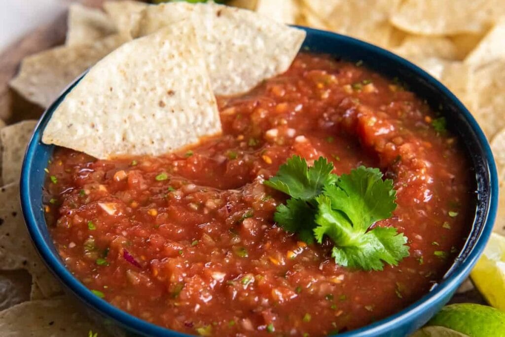 Blender salsa with tortilla chips in a bowl.