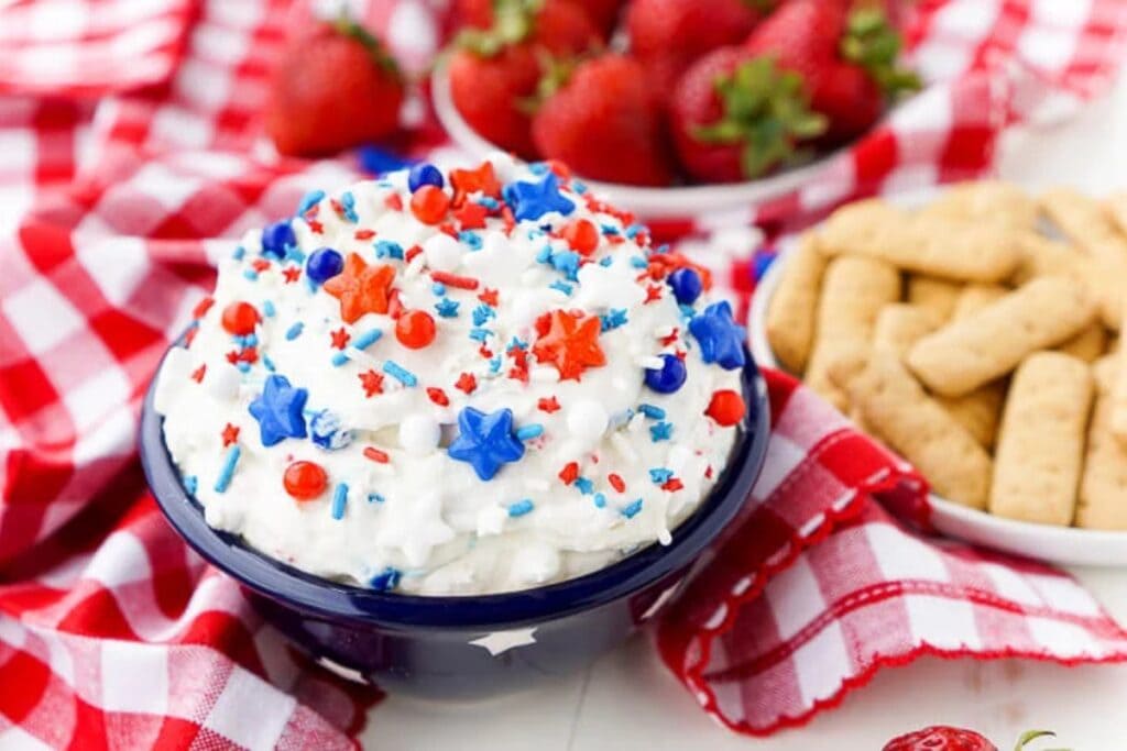 Patriotic cake batter dip topped with red, white, and blue sprinkles.
