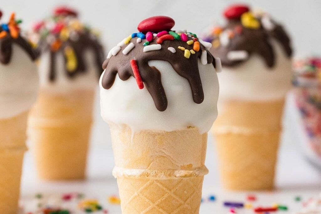 Cake pop ice cream cones with sprinkles.