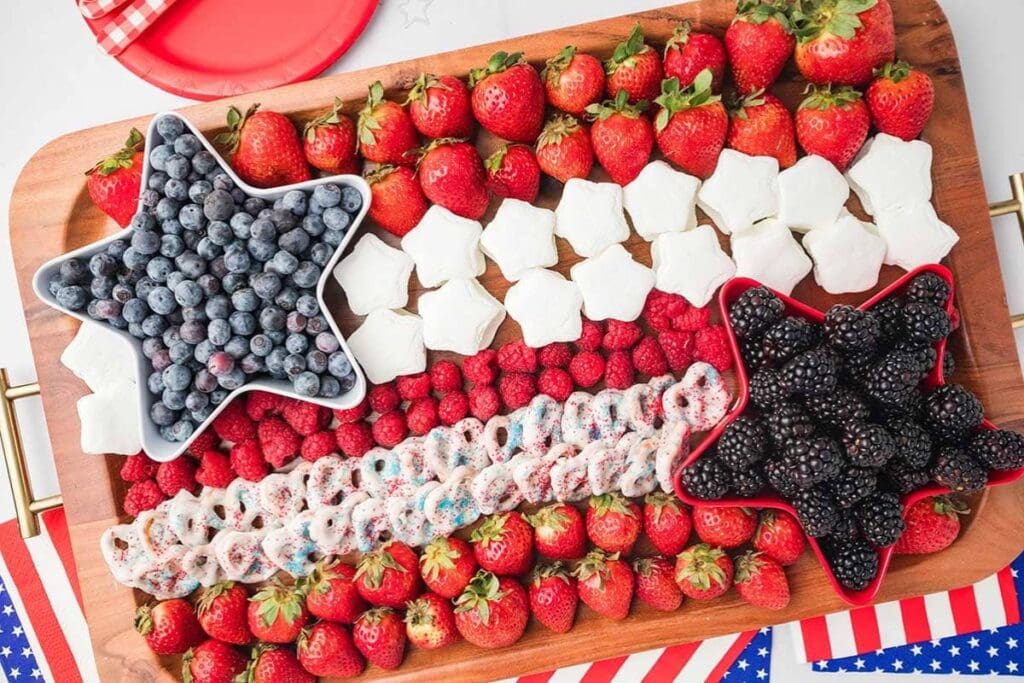 Close-up of red, white, and blue dessert charcuterie board with berries and sweets.