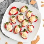 Cheesecake deviled strawberries on a plate.