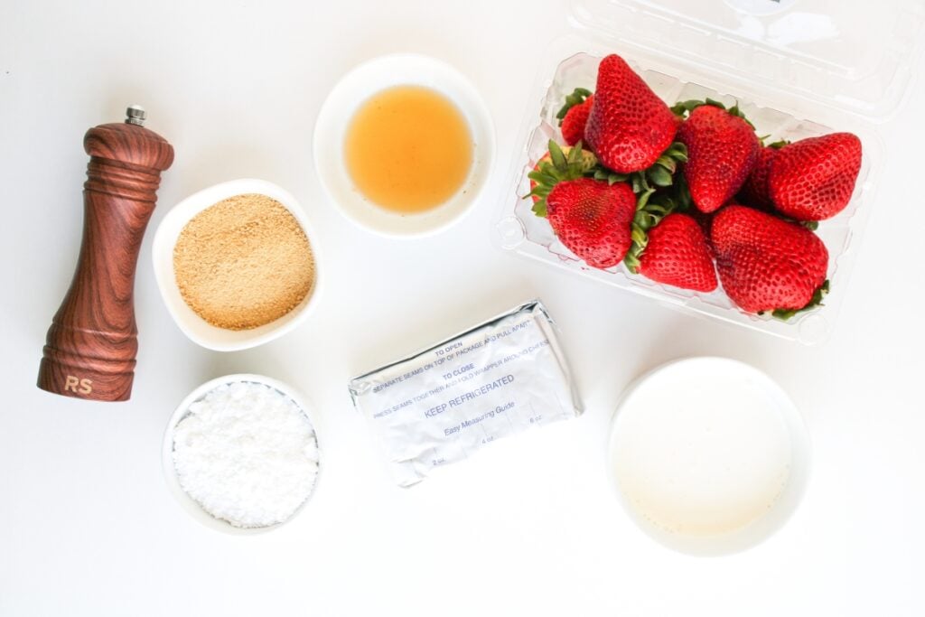 Ingredients for cheesecake deviled strawberries arranged on a table.