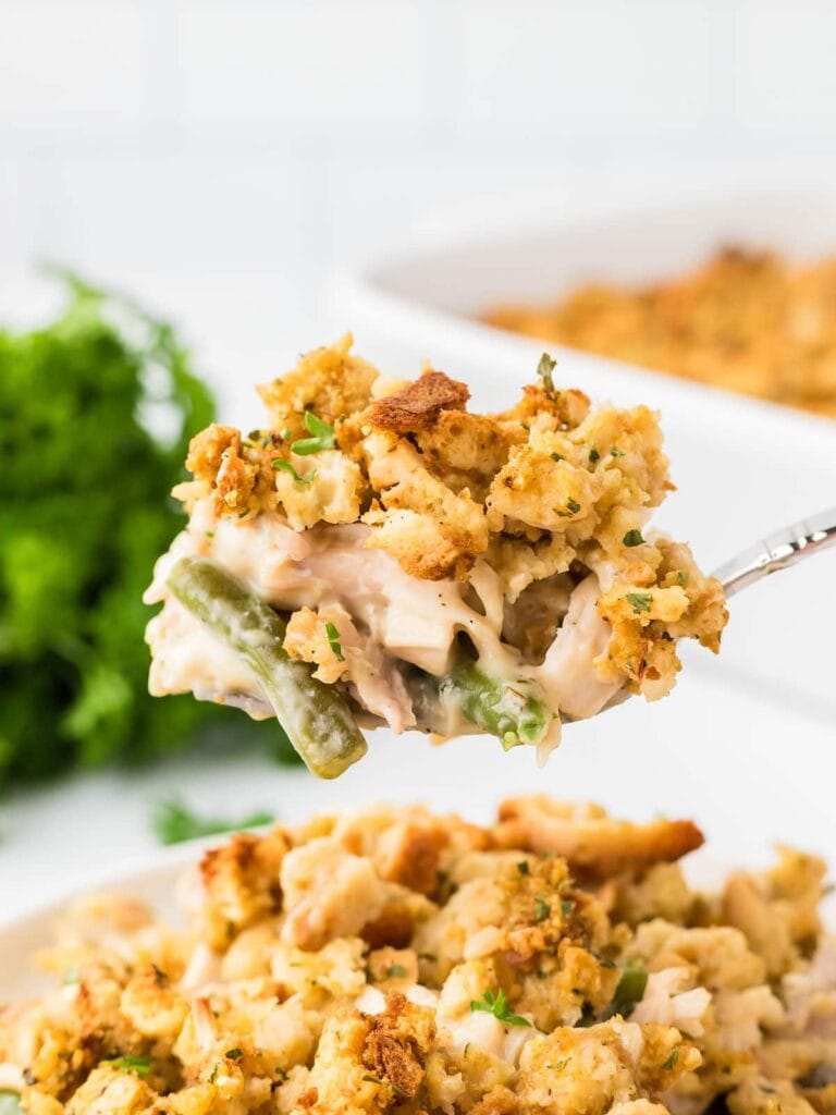 Close-up of chicken and stuffing casserole on a spoon.