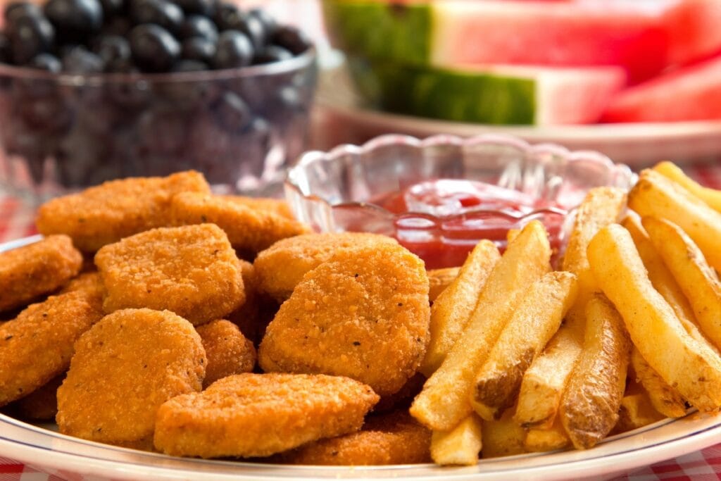 Chicken nuggets and fries on a plate.