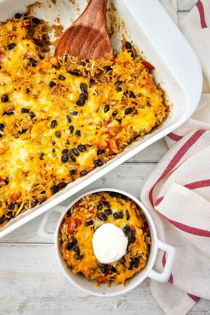 Overhead view of a cheesy chicken taco casserole in a white baking dish.