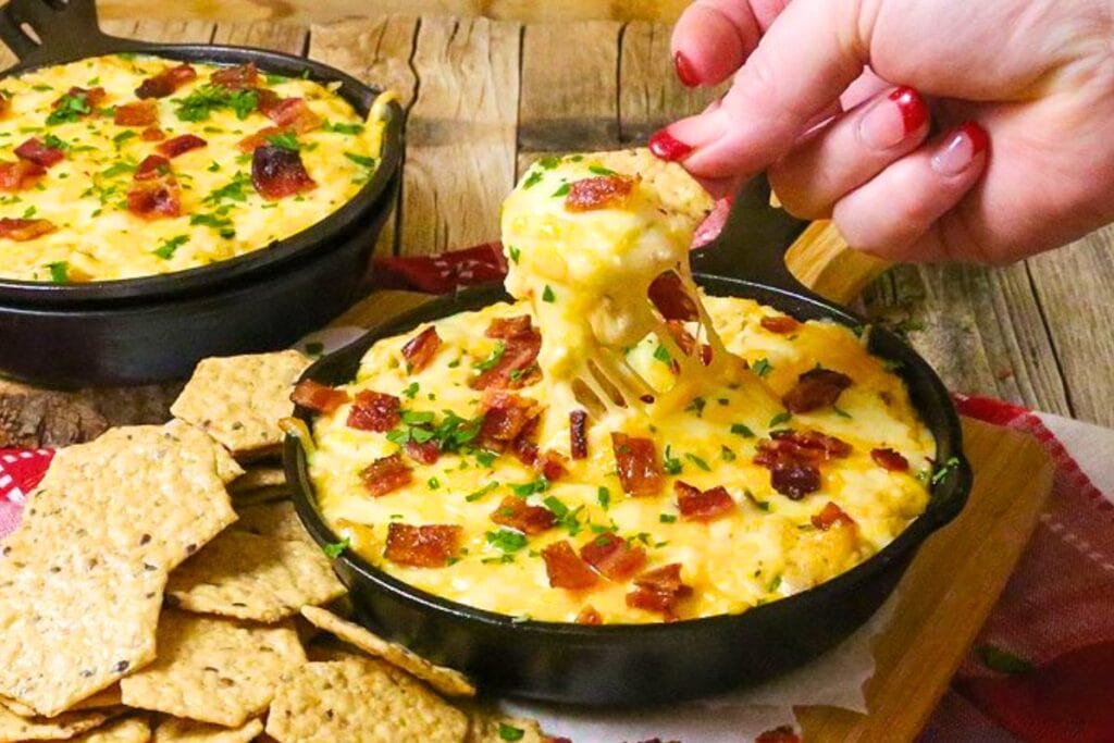 person serving themselves a hot dip that's cheesy