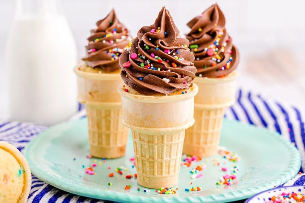 Funfetti ice cream cone cupcakes on a plate.