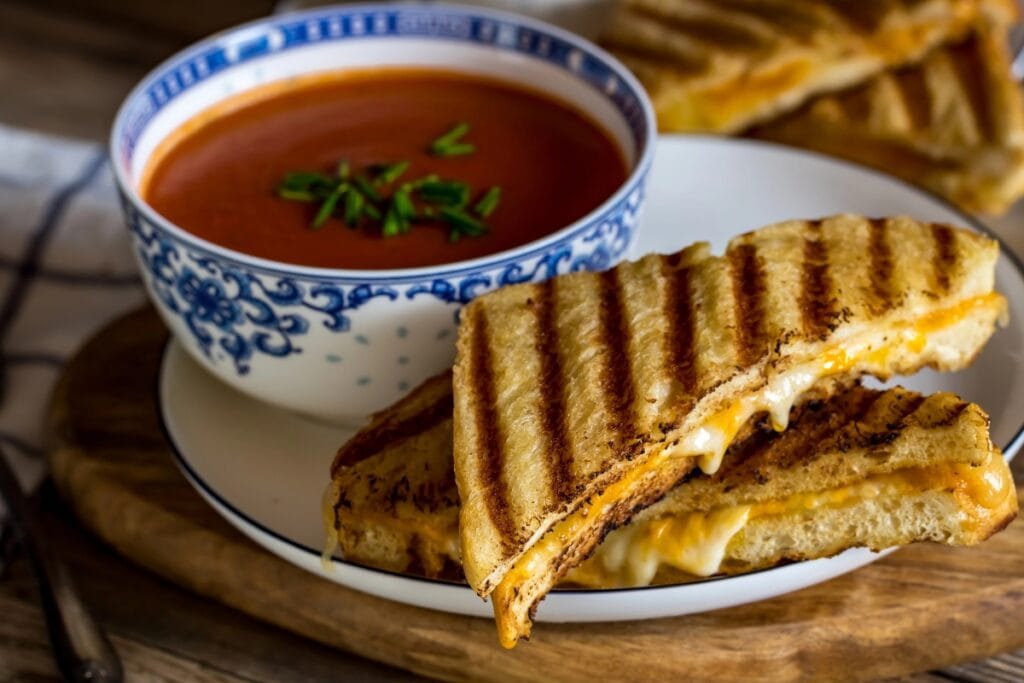 Grilled cheese with tomato soup on a plate.