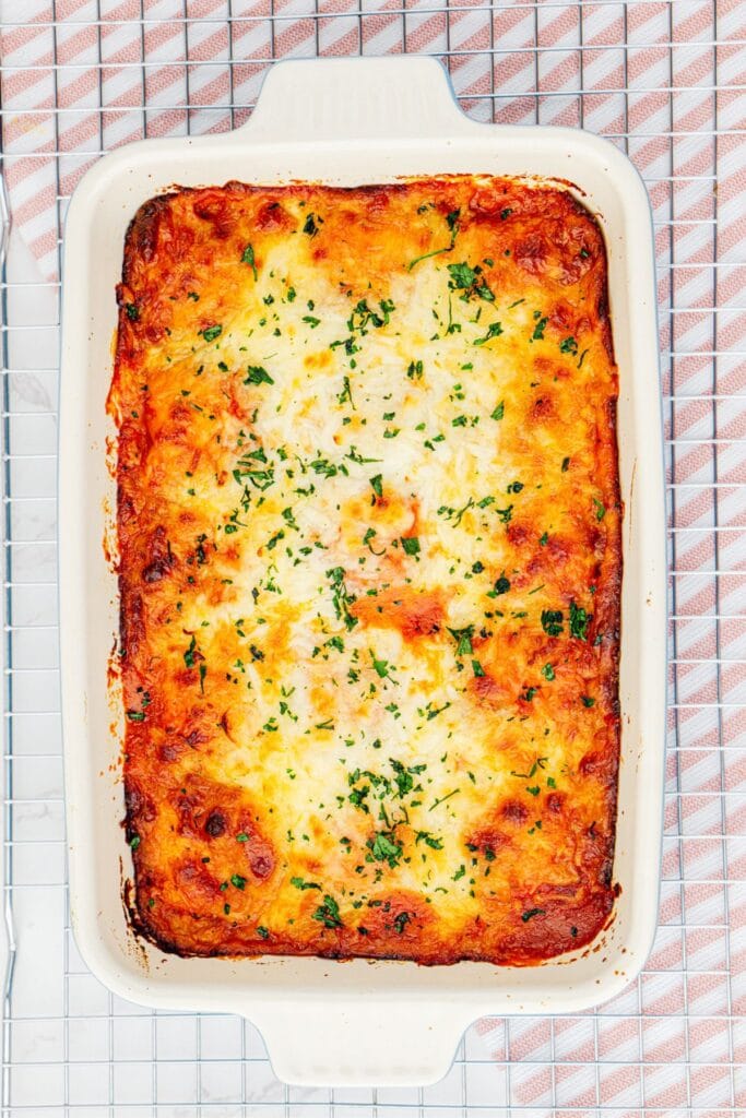 Lazy lasagna with ravioli topped with melted cheese in a baking dish.
