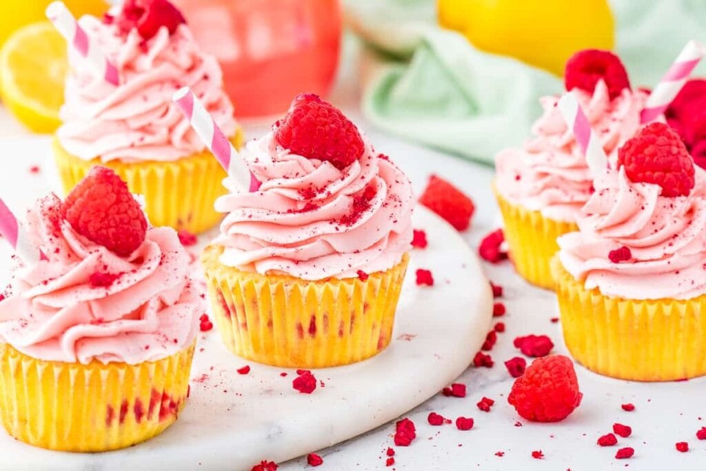 Lemon raspberry cupcakes with pink frosting on a plate.
